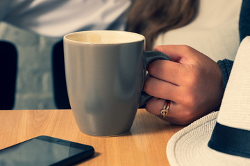 The female hand holds a cup of tea.