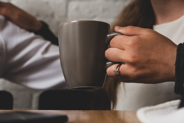 The female hand holds a cup of tea.