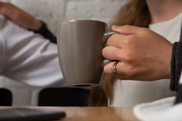 The female hand holds a cup of tea.