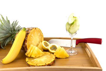 Pineapple, passion fruit, banana in wooden tray, white background isolated.Concept C vitamins in fruit
