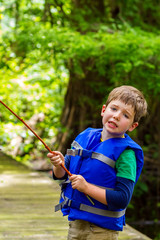 Exasperated Little Boy Looks at the Camera in Frustration Because His Fishing Pole is Caught in a Tree