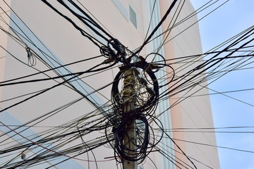 Fototapeta premium Large steel eletric support with a lot of tangled wires, cables. Complete confusion and mess