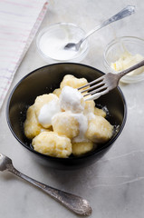 Lazy vareniki with cottage cheese (nioki) with sugar, butter and sour cream. Traditional European cuisine.