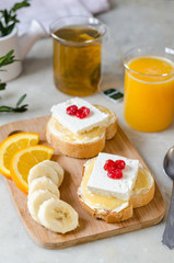 A sandwich with butter, honey and soft cheese. The concept of a healthy and tasty breakfast.