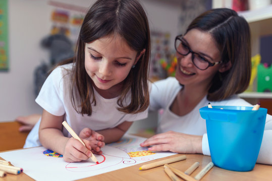 Mother with her child having creative and fun time drawing