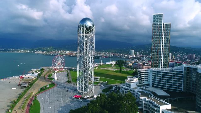 Panoramic aerial slow motion shot of alphabetic tower, skyscrapers and embankment of beautiful city of Batumi, Georgia
