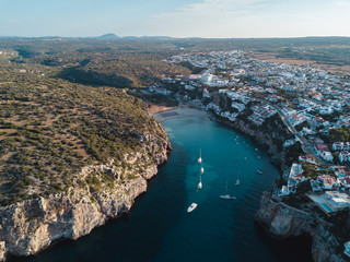 Naklejka premium Aerial bird's eye view drone of boat docked in mediterranean tropical beach with turquoise - sapphire waters