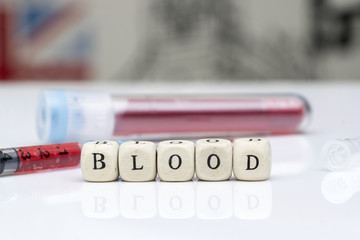 Obraz premium the 'BLOOD' concept of blood samples in the test tube, the droplets of the injection tip end