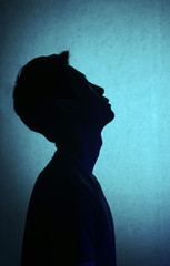Silhouette of a man deep in thought. A side view of a person who is seriously concerned.