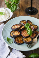 Fried eggplant slices with basil on a plate                               