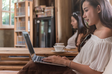 Two teenage women meet in coffee shop use laptop play social media have fun together in afternoon, life style of new teenager