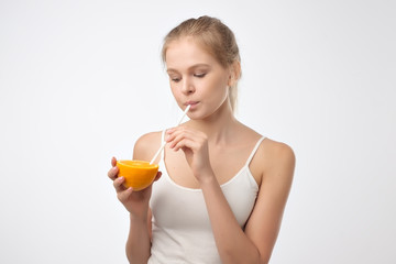 Woman drinking orange juice smiling from fruit. Fresh beverage concept