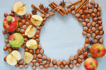 Fresh apples, hazelnuts and spices - anise stars and cinnamon on the gray kitchen table. Autumn food texture background with copy space for text. Top view