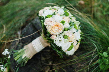 Close-up photo of wedding bouquet made of roses on the stump.