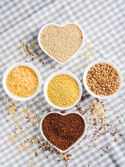 Gluten free grains quinoa, rice, buckwheat, amaranth, millet in bowls on kitchen table. Celiac diet