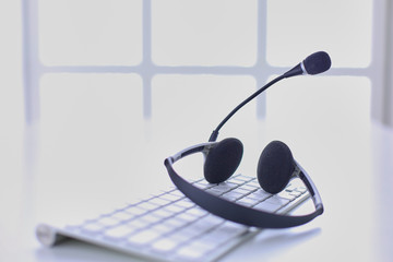 Call center and customer service help desk. VOIP headset on laptop computer keyboard