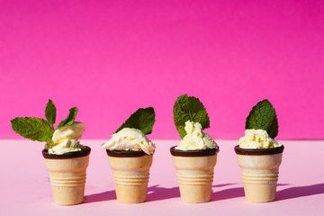 Ice cream in waffle with mint leaves, pink background