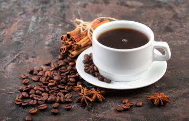 Coffee beans and cinnamon on a background of burlap. Roasted coffee beans background close up. Coffee beans pile from top with copy space for text. Seasoning. Spice. Cinnamon. Badian. Coffee house.