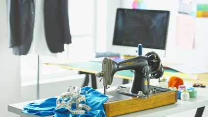 Retro sewing machine on designer clothes desktop