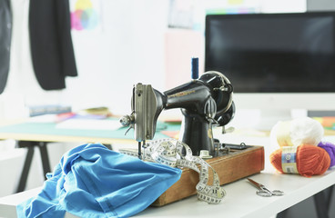 Retro sewing machine on designer clothes desktop