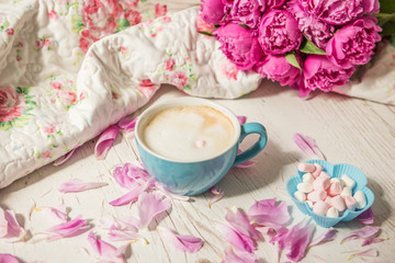Fototapeta na wymiar Coffee with milk and flowers pink peonies. The atmosphere of relaxation. 