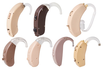 Set of old hearing aids on white background isolated, alternative to surgery