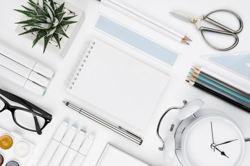 White tabletop with office supplies and blank notebook in center - Powered by Adobe