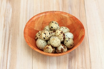Partridge eggs in bowl  /  Quail spotted eggs  in a bowl on wooden table
