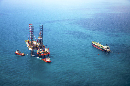 Oil rig in the gulf with oil tanker ship