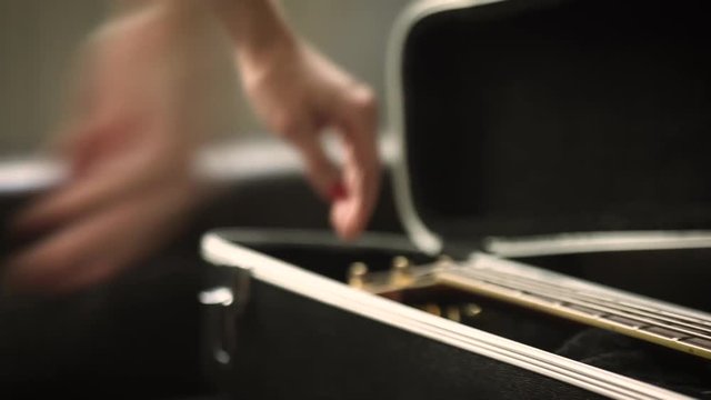 The girl takes out the guitar from the case