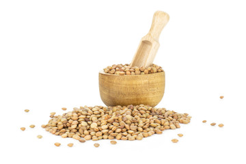 Lot of whole raw green lentil seeds in a wooden bowl with scoop in it isolated on white