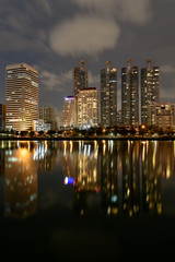 Modern buildings of Benchakitti Park with lights reflection in night city