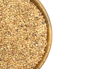 Lot of whole raw green lentil seeds in a wooden bowl flatlay isolated on white