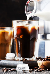 Summer cold coffee with ice and milk, brown background, selective focus and shallow DOF