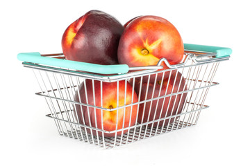 Lot of whole ripe deep red nectarine in a shopping basket isolated on white