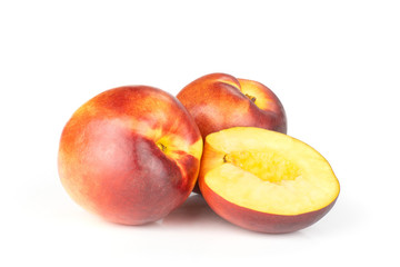 Group of two whole one half of ripe deep red nectarine isolated on white