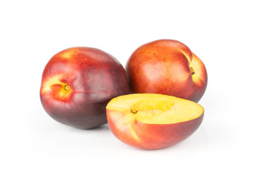 Group of two whole one half of ripe deep red nectarine isolated on white
