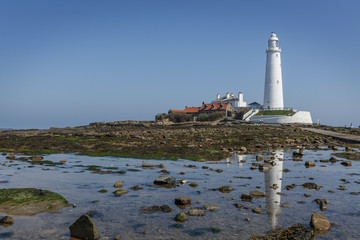 Landscape view of St. Marys Lighthouse on a summers day, and its reflection