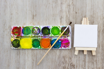Easel, multicolors paint and brush for drawing. Creativity and painting concept