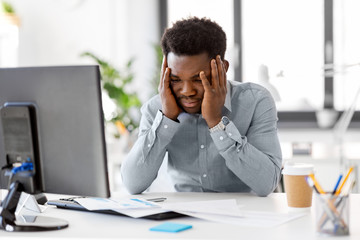 business, people, deadline and technology concept - stressed african american businessman with papers and computer working computer at office - obrazy, fototapety, plakaty