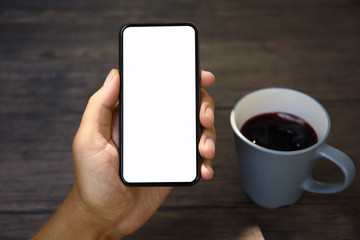 Male hands holding phone with isolated screen over the table