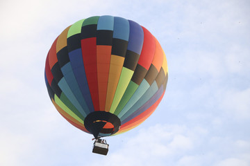 Naklejka premium colorful hot air balloon against blue sky. hot air balloon is flying in white clouds. beautiful flying on hot air balloon