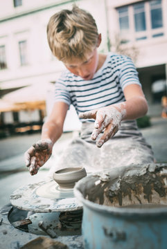 Traditional craft lesson: boy try to make a pottery bowl