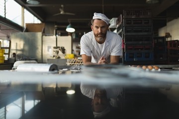 Portrait of male baker standing in bakery shop
