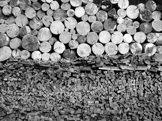 Sorgfältig gestapeltes Holz, Vierkanthölzer und Stämme, vor einem alten Bauernhaus auf dem...