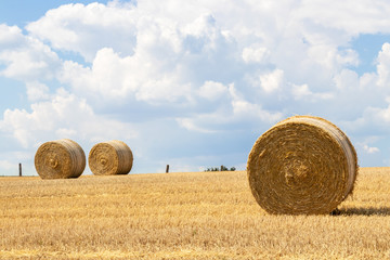 Harvest time in front of a beautiful sky, field with hay bales in the Lüneburg Heath, Northern Germany.