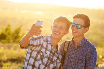 two cute guys take selfies happy friends are photographed on the phone