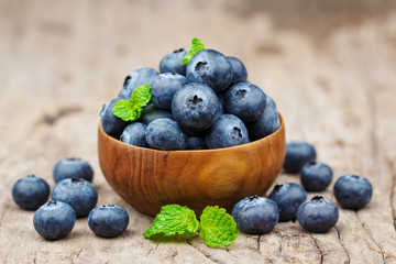 Blueberries in a wood bowl on a wooden table, Healthy eating and nutrition concept
