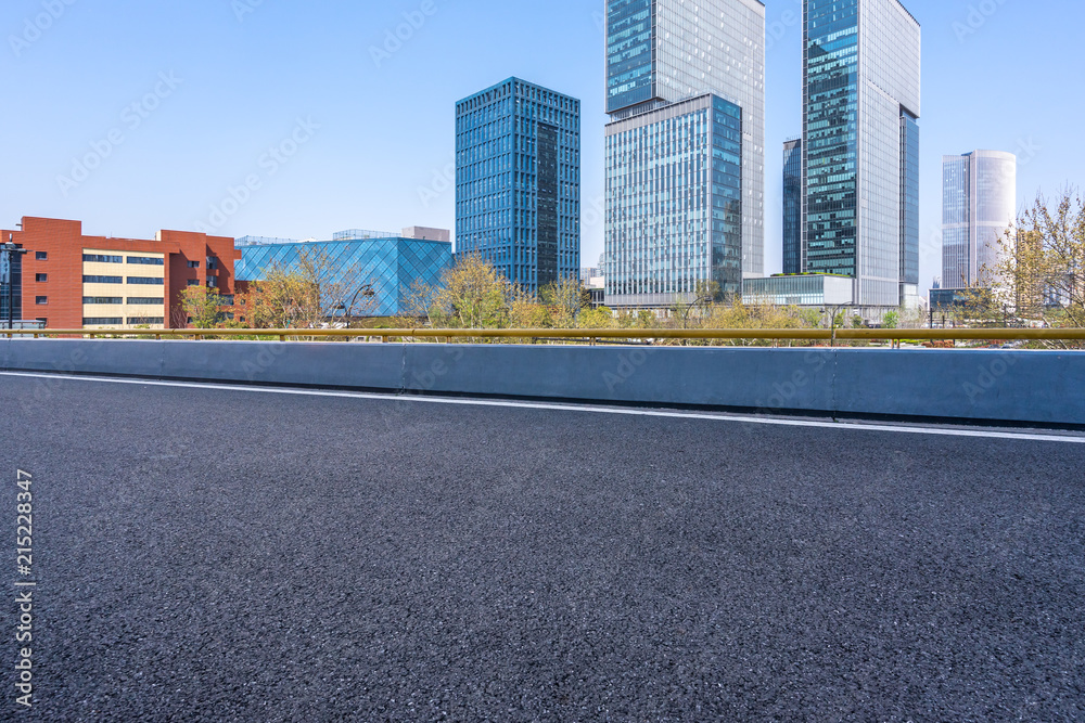 Wall mural city skyline with asphalt road in urban