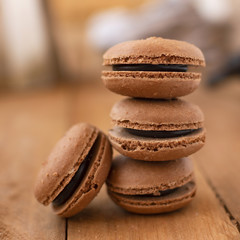 Chocolate macarons on a wooden table, with a vintage style.